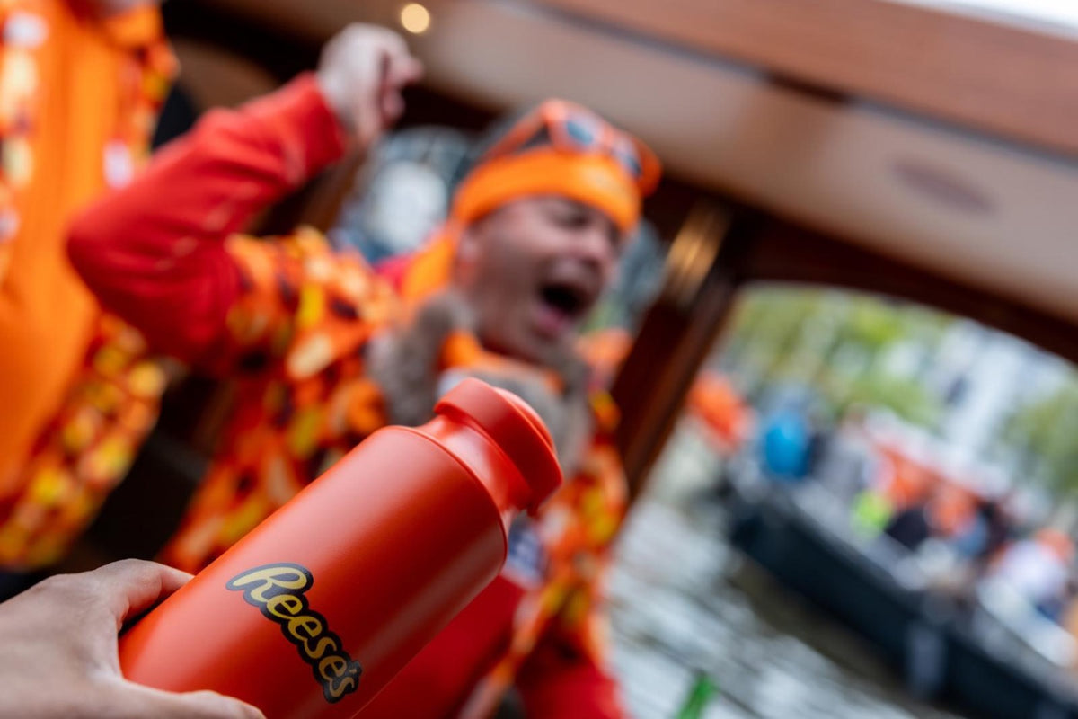 Ampolla Fluye taronja amb el logotip de Reese's gravat